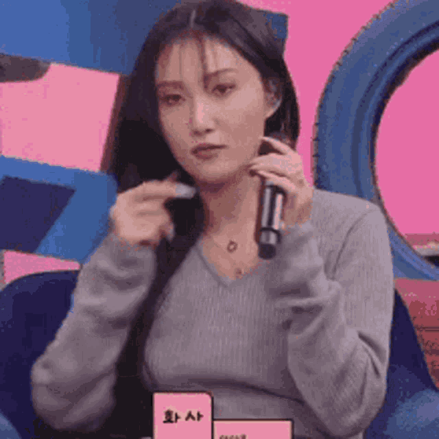 a woman is holding a microphone in her hand while sitting in a chair .