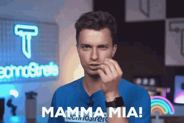 a man wearing a blue shirt with the word mamma mia on it