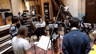 a group of musicians are playing in a room with a sign that says vr