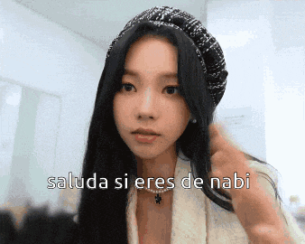a woman wearing a hat and a necklace says " saluda si eres de nabi " in spanish