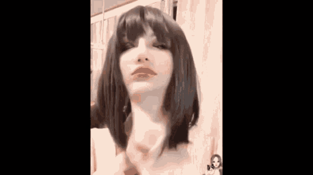 a woman wearing a wig and red lipstick is holding her neck .
