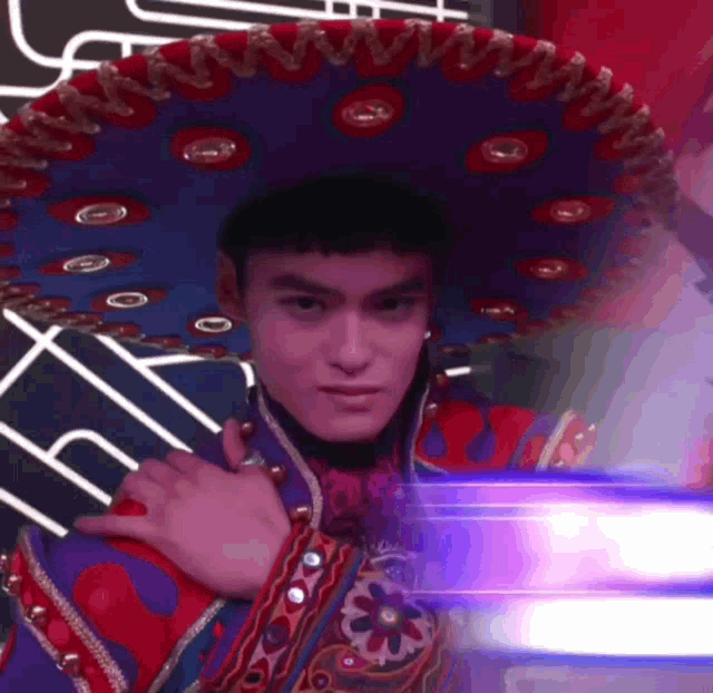 a man wearing a sombrero and a purple and red outfit