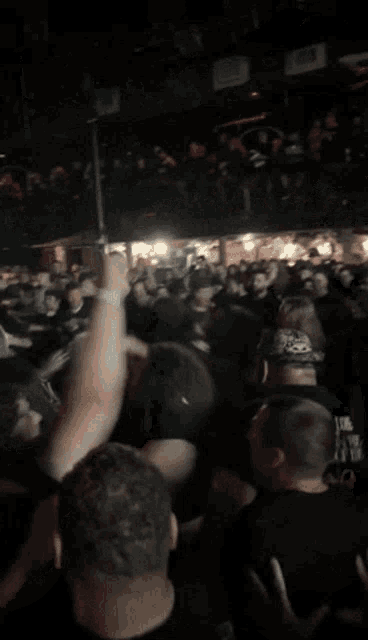 a crowd of people at a concert with one man wearing a shirt that says ' heavy metal '