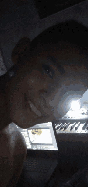 a man is smiling in front of a keyboard