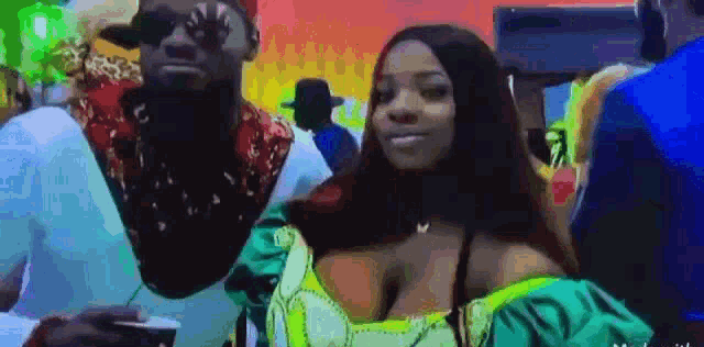 a man and a woman are standing next to each other in a crowded room .