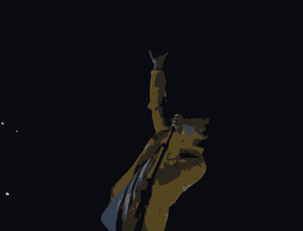 a man in a yellow jacket is singing into a microphone in the dark