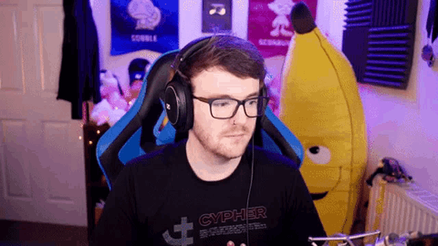 a man wearing glasses and headphones has a shirt that says cypher