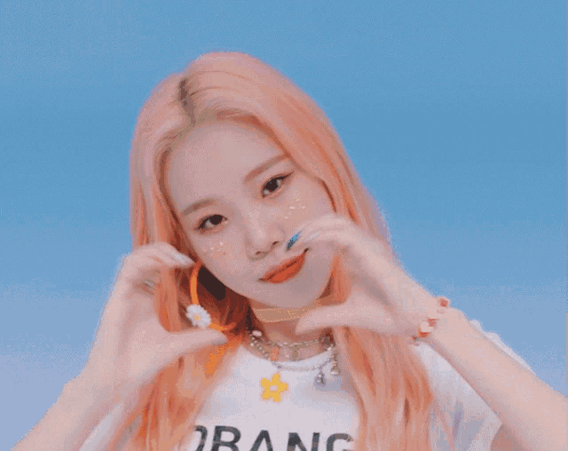 a girl with pink hair wearing a white shirt that says orang