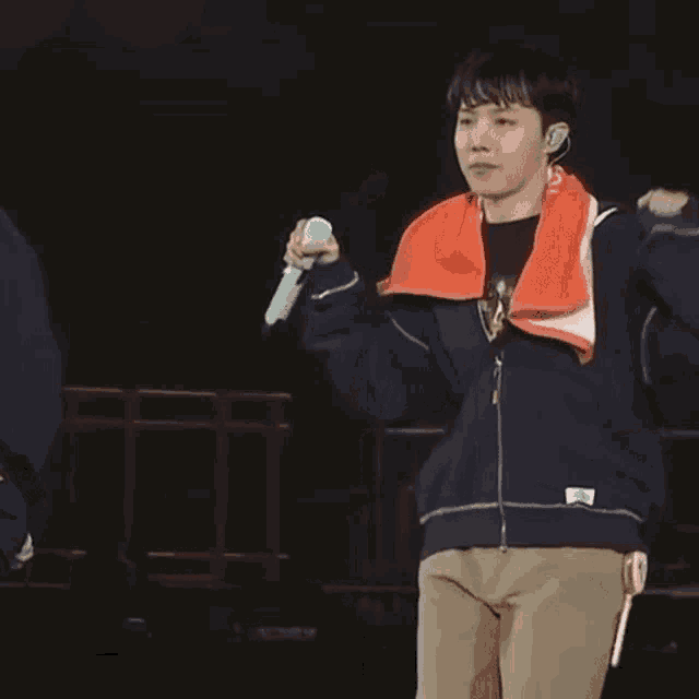 a young man is holding a microphone on a stage .