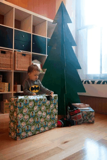 a child wearing a batman shirt sits on a green box