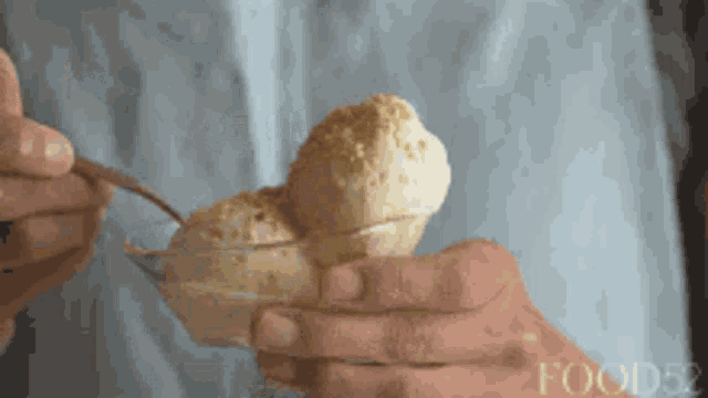 a person is holding a bowl of ice cream with a spoon and the words food52 on the bottom right