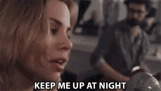 a woman is singing into a microphone with the words `` keep me up at night '' written above her .
