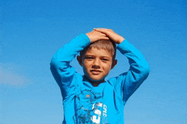 a young boy wearing a blue shirt that says ' gpa ' on it