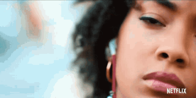 a close up of a woman 's face with a netflix logo on the bottom