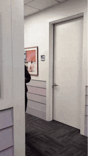 a white door in a hallway with a picture on the wall above it