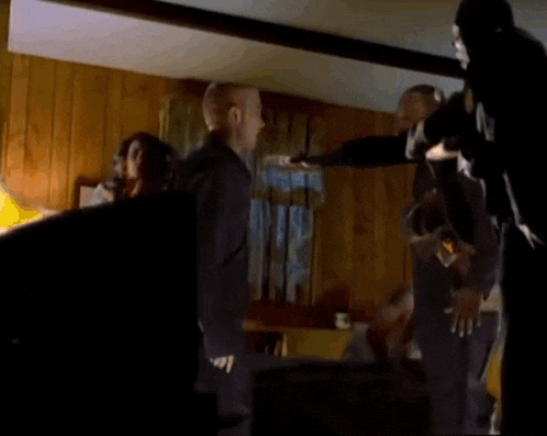 a group of people are standing in a room fighting .