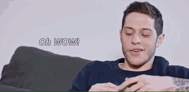 a man is sitting on a couch with his eyes closed and the words oh wow behind him