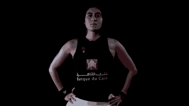 a woman wearing a black tank top with a logo on it