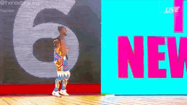 a man is standing in front of a colorful sign that says `` i 'm new '' .