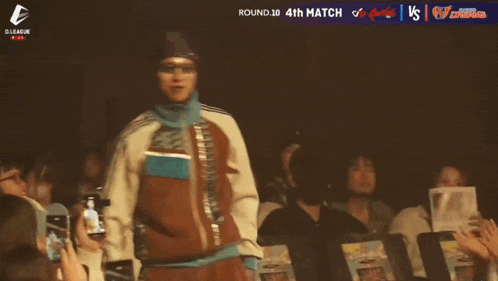 a man in a red jacket stands in front of a crowd and says hibiki on the bottom