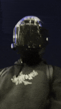 a man wearing a helmet and a black hoodie with the word white on the front