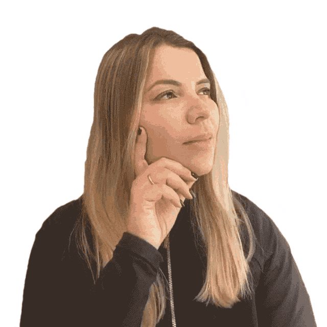 a woman with long blonde hair holds her hand to her face