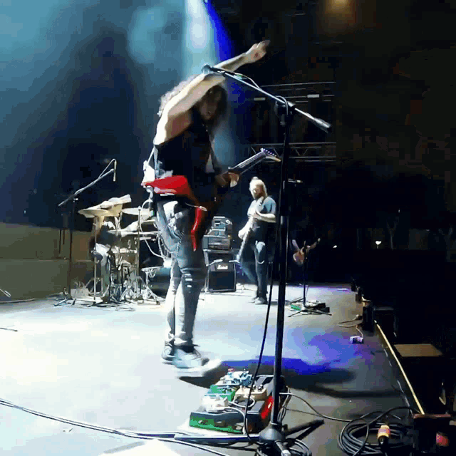 a man is playing a guitar on a stage