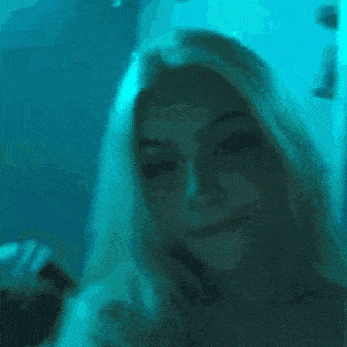 a blurry picture of a woman 's face with blue lights behind her
