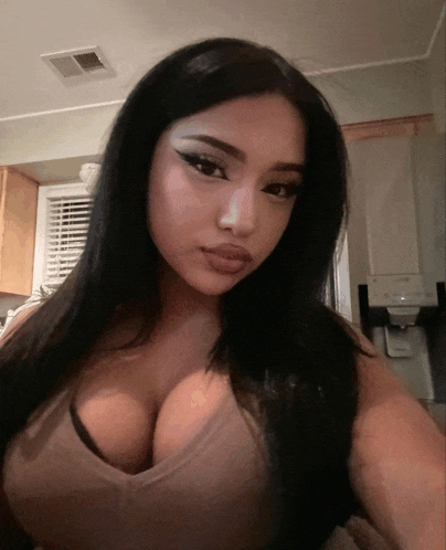 a woman is taking a selfie in front of a fridge
