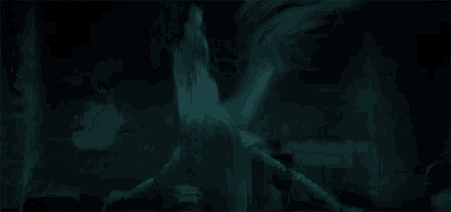 a woman with long white hair is laying on the ground in a dark room