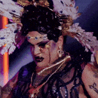 a drag queen has a tattoo on her arm that says ' x ' on it