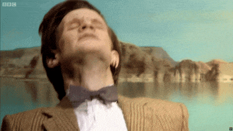 a man in a suit and bow tie looks up at the sky with bbc written on the bottom