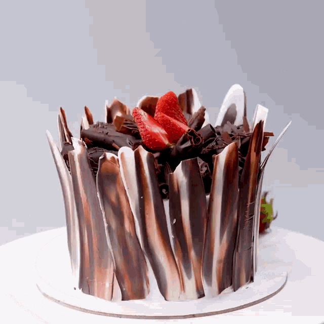 a chocolate cake with strawberries on top and chocolate shavings