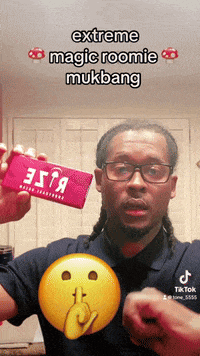 a man in a blue shirt is holding a red box that says extreme magic roomie mukbang