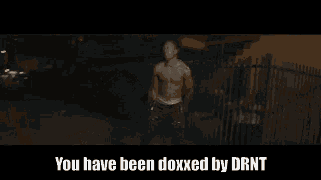 a man is standing in a dark room with the words you have been doxxed by drnt below him
