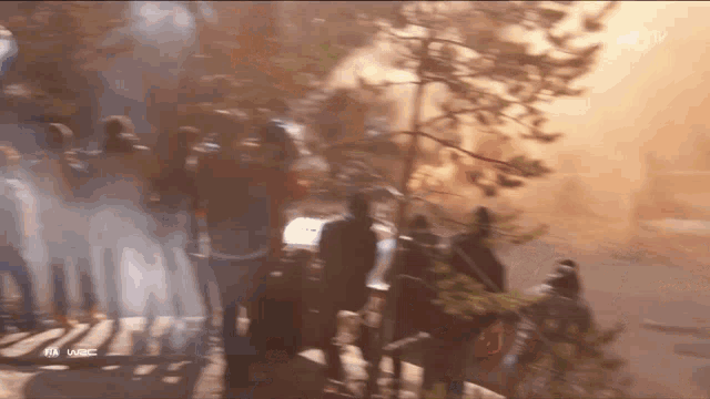 a group of people watching a race with the word wrc on the bottom left