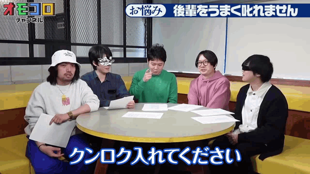 a group of people sitting around a table with japanese writing on the top