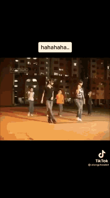 a group of people are dancing on a street at night and they are laughing .