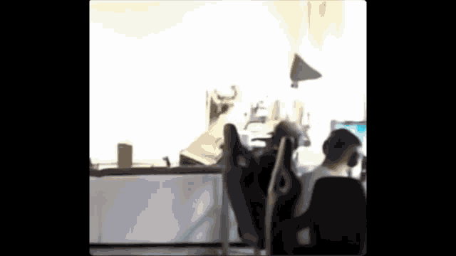 a man is sitting in a chair in front of a computer screen