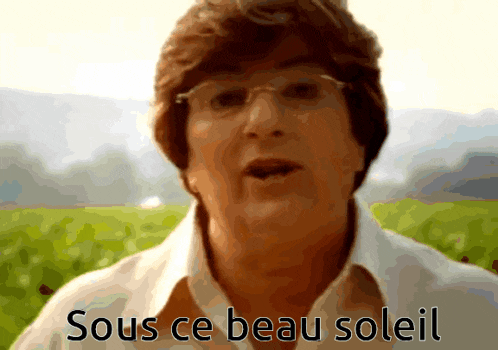 a woman with glasses says " sous ce beau soleil " in front of a field