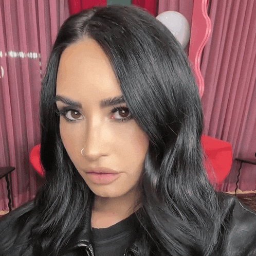 a close up of a woman 's face with black hair and a nose ring