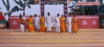 a group of people are dancing in front of a ganeshvideos banner