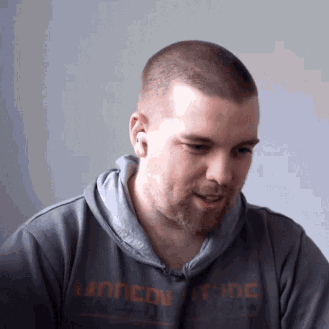 a man wearing a grey sweatshirt that says london trade