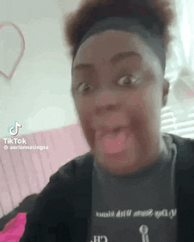 a woman is making a funny face while wearing a headband and a black shirt .