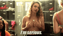 a naked woman says i 'm serious in front of a locker