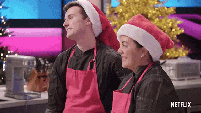 a man and a woman wearing santa hats with netflix written on the bottom right