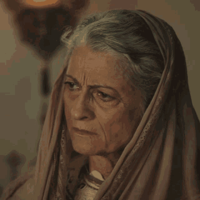 a woman with gray hair and a scarf on her head