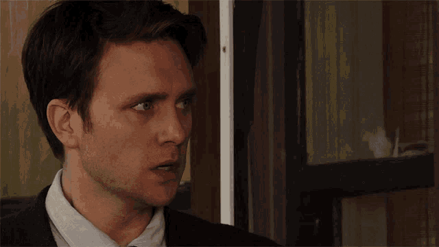a man in a suit and tie looks at something