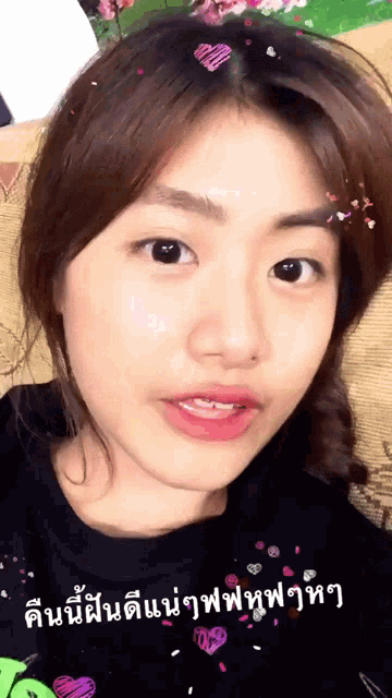 a close up of a woman 's face with foreign writing on her shirt