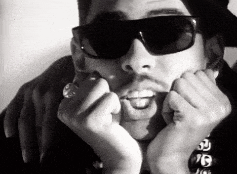 a man wearing sunglasses is making a funny face